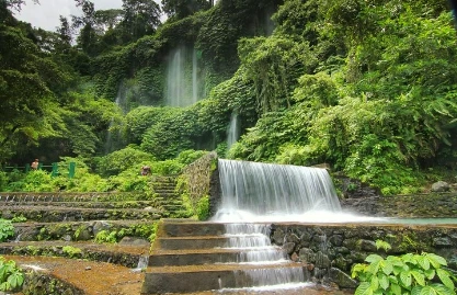 Water falling over green rock in Central Lombok